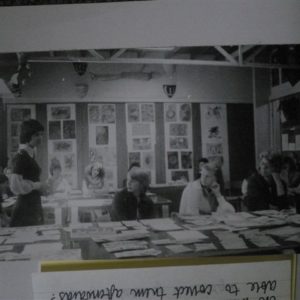 Students in a class discussion, with art on the walls and in front of them