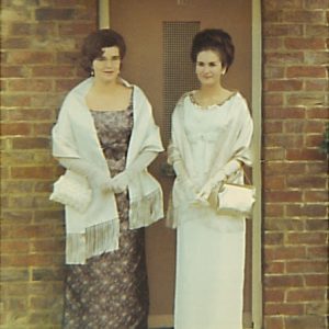 Two female students dressed for the Student Ball standing outside their hall of residence.