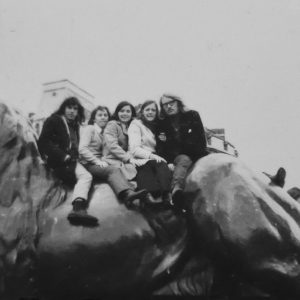 Students on one of the lions in Trafalgar Square during a field trip.