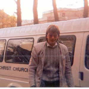 Grenville Hancox, Head of Music, standing next to a Christ Church minibus.