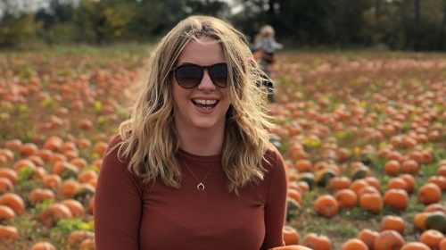 Molly New standing in a pumpkin field